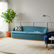 Modern living room with a blue sofa, armchair, and decorative elements.