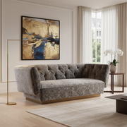 Gray tufted sofa in a modern living room with abstract art and large windows.
