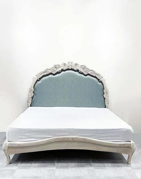 king‑size bed in off‑white with hand-carved Sheesham frame, premium upholstered headboard.