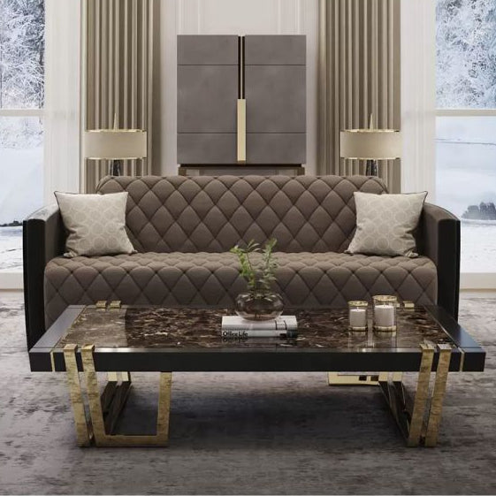 A modern three-seater Chesterfield sofa with a polished wooden leg base, upholstered in a grey fabric, positioned in a well-decorated living room setting.