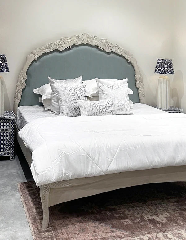 king‑size bed in off‑white with hand-carved Sheesham frame, premium upholstered headboard.
