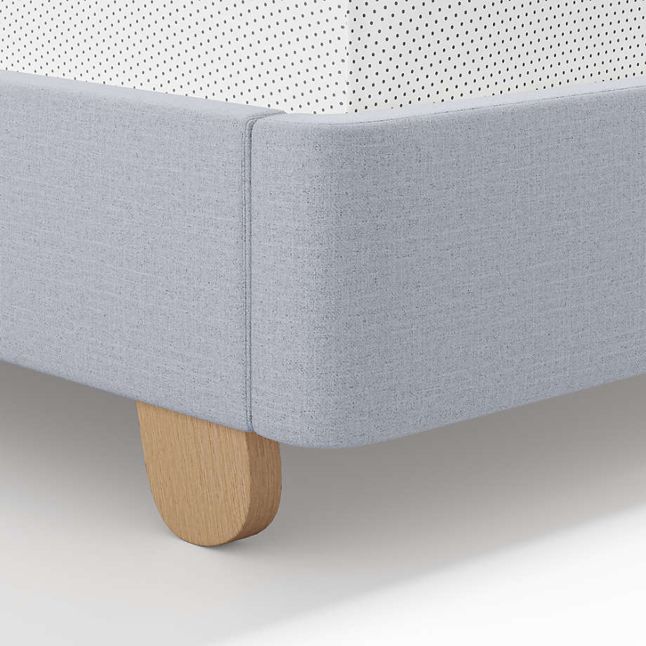 King Size Upholstered Kids Bed features a modern wingback design, soft blue upholstery, rounded oak legs, and stylish comfort with lasting quality