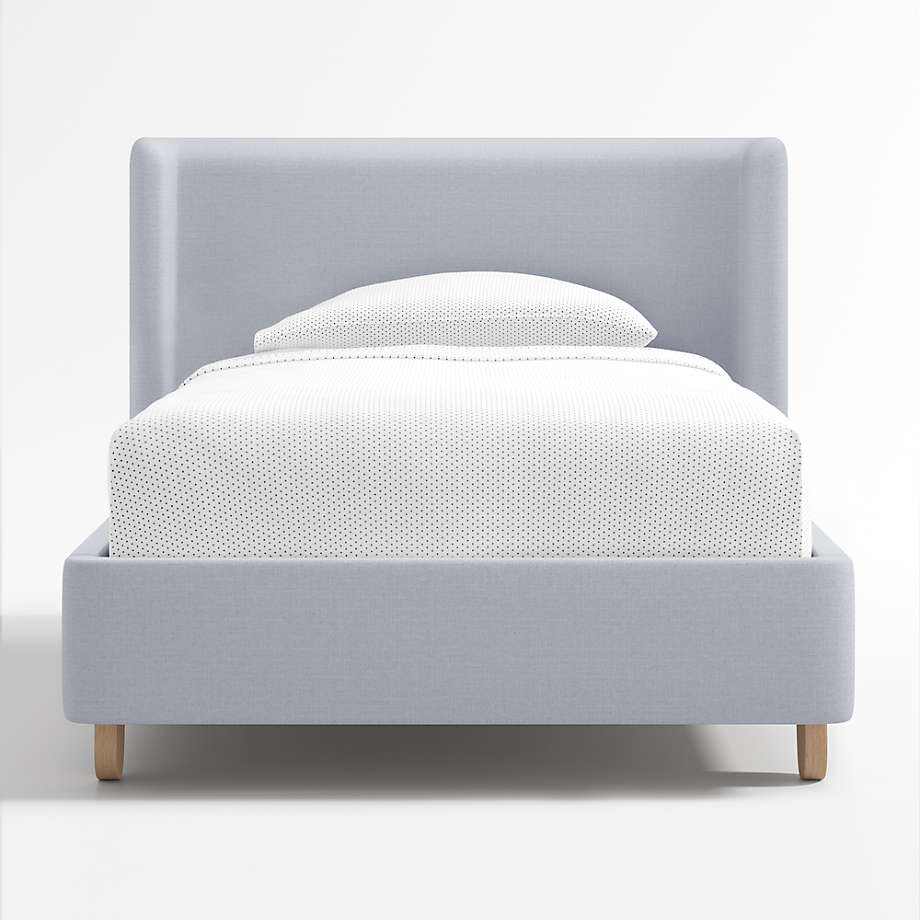 King Size Upholstered Kids Bed features a modern wingback design, soft blue upholstery, rounded oak legs, and stylish comfort with lasting quality
