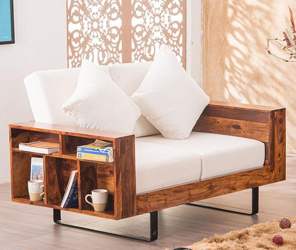 Wooden sofa with white cushions and bookshelves in a living room setting
