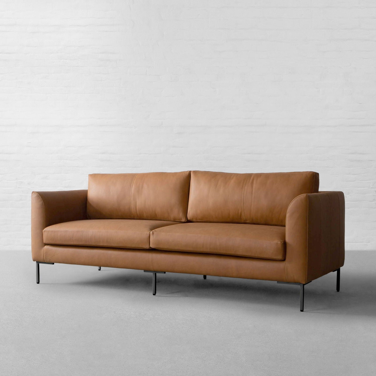 Four Seater Leatherette Sofa with hardwood frame Solid metal legs in black matte finish. -