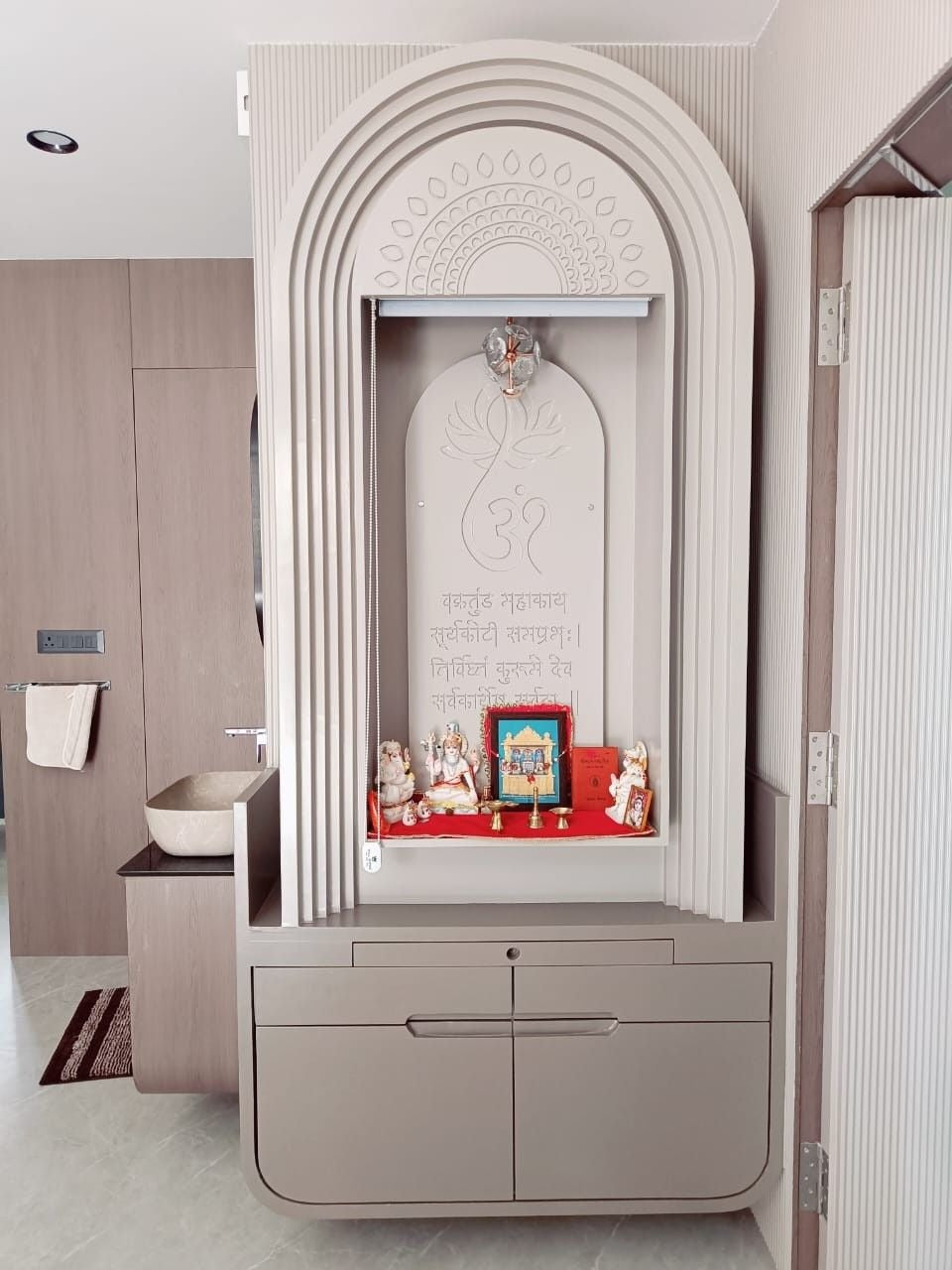 Contemporary Pooja Unit with Layered Arch Design & Subtle Carved Detailing in Neutral Tones